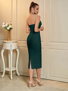 Detail view of the back zipper and side slit on this emerald green bandage midi dress