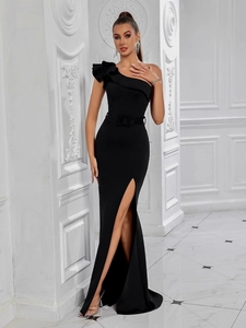 Detail of elegant black one-shoulder evening gown with ruffle trim and high slit skirt
