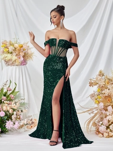 Detail of sequined off-shoulder gown in emerald green with waist corset and side slit