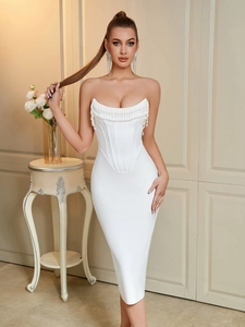 Detail of white strapless bandage dress showing pearl fringe and corset-style bodice