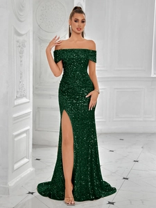 Detailed macro of deep green sequin fabric on an off-shoulder evening gown with side slit
