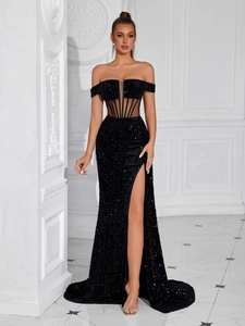 Detail of corset waist and high slit on a black sequin off-the-shoulder evening gown