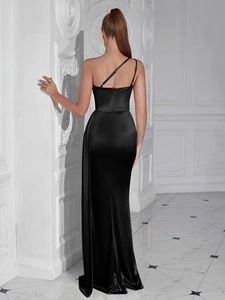 Macro detail of high-shine black satin fabric and side slit on the evening dress