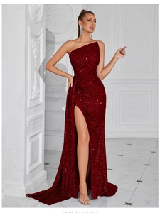 Dettaglio del tessuto di paillettes rosso scuro e dell'alto spacco di questo abito da sera