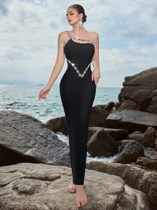 Detail of elegant black slim-fit evening dress featuring crystal rhinestones and asymmetrical shoulder