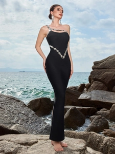 Detailed view of luxury black evening dress with asymmetric neckline and rhinestone flowers