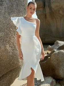Detailed view of elegant white one-shoulder dress with side ruffles and fishtail hem