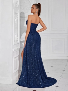 Detailed view of the sparkling navy blue sequins and side slit on this strapless evening gown