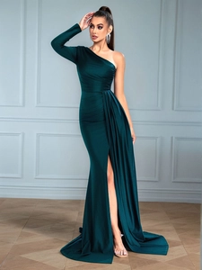 Detail of emerald green satin dress featuring asymmetrical ruching and a high slit
