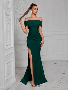 Detail shot of the off-shoulder neckline and elegant side slit on a dark green evening gown