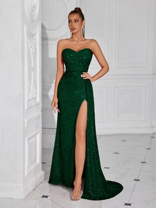 Close-up detail of dark green sequin fabric and side slit of the strapless evening gown