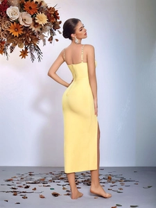 Close-up of bright yellow bandage dress featuring open back and side slit detail