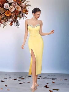 Detail of elegant pale yellow evening gown with silver rhinestone trim and high side slit