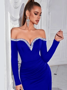 Detail of off-shoulder evening dress with handcrafted pearls and crystals on blue fabric
