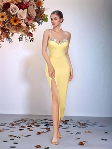 Detail of elegant yellow bandage dress with rhinestone straps and high side slit