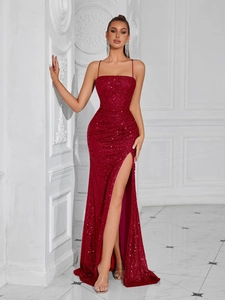 Detailed view of the sparkling burgundy sequin fabric and high slit on the evening dress