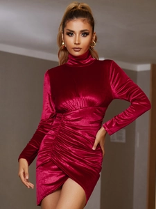 Détail d'une robe en velours rouge plissé avec col montant et ourlet asymétrique