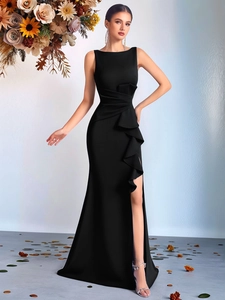Close-up of elegant waist pleats and layered ruffle detail on a slim black evening dress