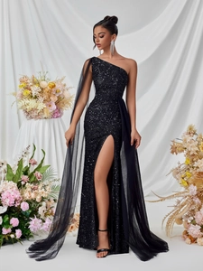 Detail of elegant black sequin evening gown with a mesh shoulder cape and high leg slit