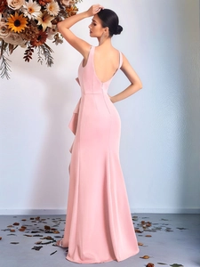 Detail of elegant pale pink evening dress featuring stylish waist ruffles and backless design