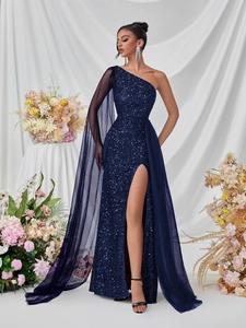 Detail of sequined navy blue one-shoulder evening gown with a flowing mesh cape sleeve