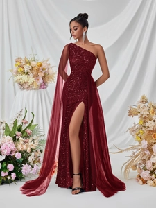Detail of burgundy sequin gown featuring a chic one-shoulder design and mesh cape