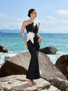 Detail eines schwarzen One-Shoulder-Fischschwanzkleides mit weißen Zierblumen