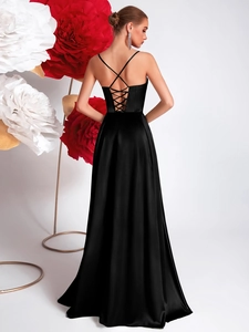 Close-up of elegant black satin evening dress featuring a corset-style lace-up open back