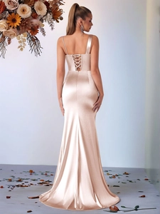 Detail of elegant champagne satin evening gown featuring a criss-cross backless design