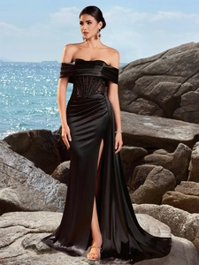 Detail of elegant black satin evening dress with lace corset waist and high side slit