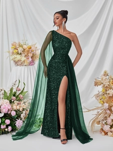 Detail of emerald green sequin dress with asymmetrical shoulder and flowing mesh cape
