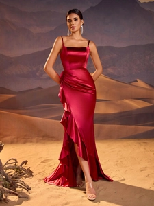Detail of the ruffle hem and irregular slit on the burgundy satin evening gown