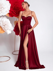 Detail of burgundy satin evening dress featuring a boned corset and high slit design