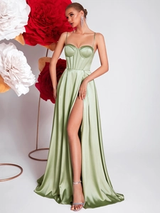 Detail of sage green satin slip dress featuring a corseted bodice and high side slit