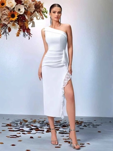 Close-up of elegant white one-shoulder dress featuring side slit and delicate lace trim