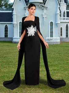 Elegante abito da sera nero aderente con decorazione floreale e maniche a cappa