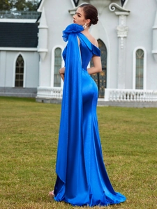 Elegant royal blue one-shoulder evening gown with pleated floral detail and flowing cape