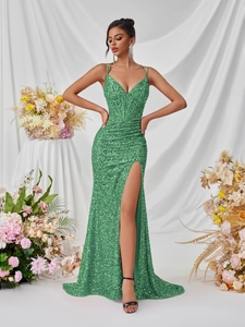 Detailed view of emerald green sequined evening dress with side slit and fishbone waist