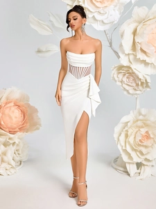 Detail of white strapless evening dress featuring sheer corset waist and ruffled slit