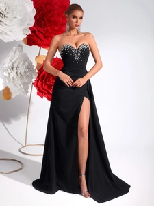 Detailed close-up of white sparkling rhinestones and beads on a black strapless gown