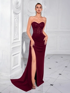 Détail du bustier à paillettes bordeaux et de la fente haute sur une robe de soirée