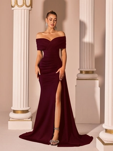 Detail of off-shoulder pleated bodice and high slit on a satin burgundy evening gown