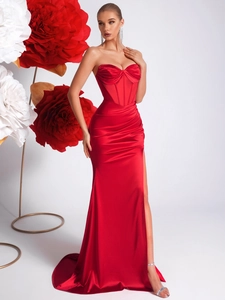 Détail de robe de soirée sirène en satin rouge avec bustier plissé et fente haute sexy