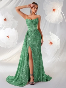 Détail d'une robe de soirée à paillettes vert émeraude avec corset et fente haute