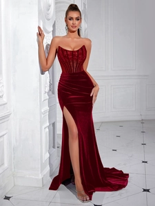 Detail of burgundy velvet evening gown showing slim-fit fishbone bodice and high slit