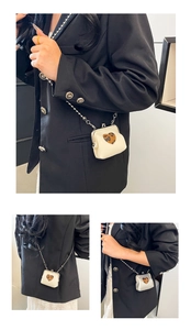 Detail view of mini chain crossbody bag with leopard print heart and gold clasp