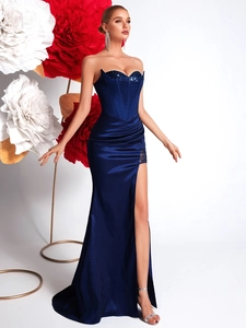 Dettaglio dell'abito da sera in raso blu navy con paillettes e spacco alto sulle gambe