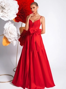 Detailed view of red evening dress featuring a large bow waist accent and layered pleated skirt