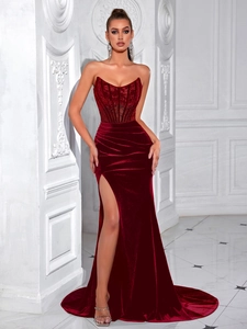 Detailed view of burgundy velvet evening gown featuring a corset top and high leg slit