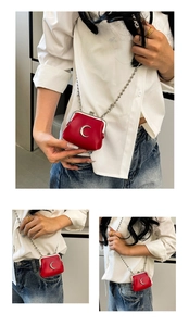 Detail of red mini kiss-lock purse with silver crescent logo and sleek chain strap